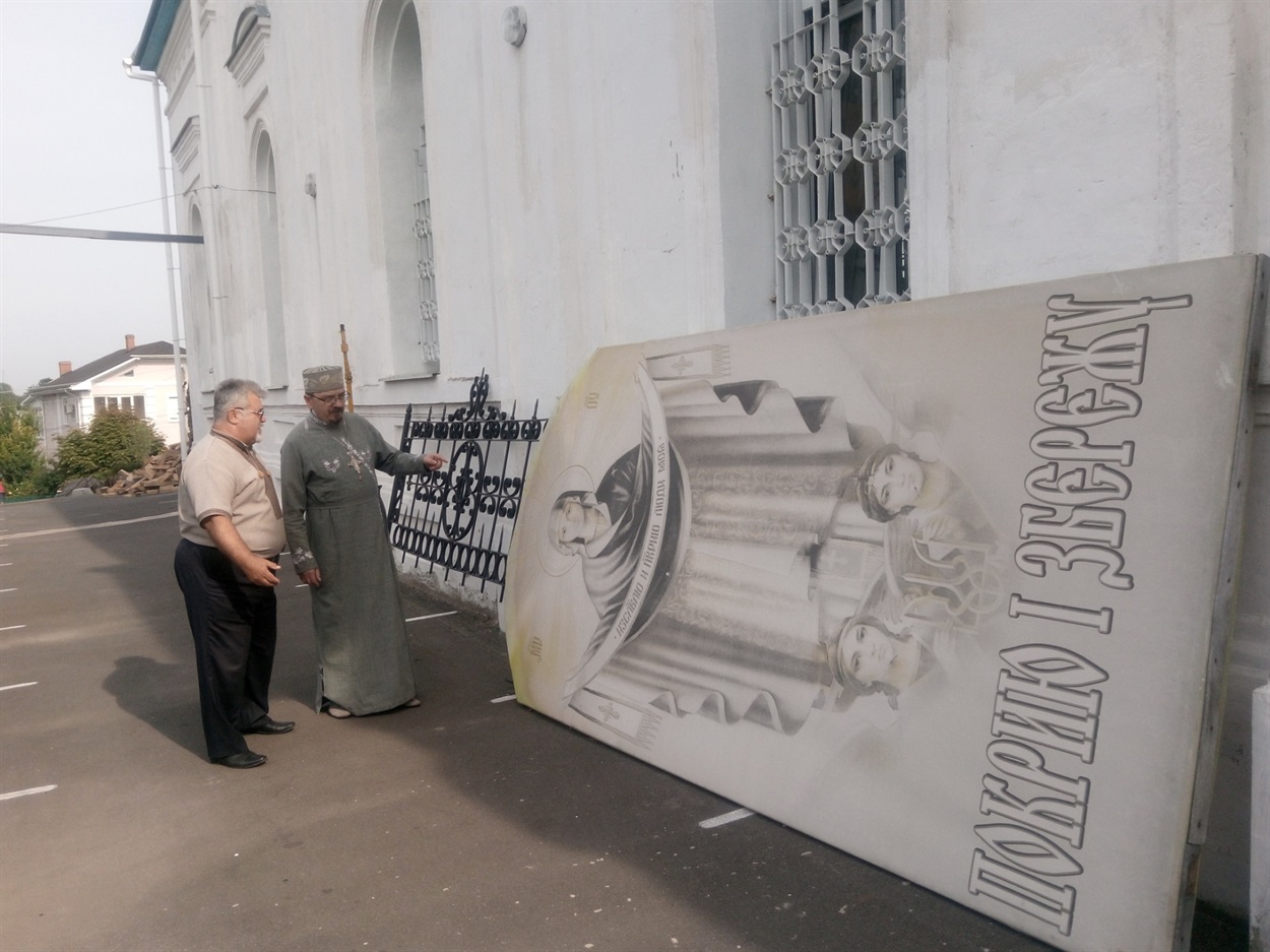 Юрій Муквич, керівник Ніжинського академічного українського драматичного театру імені Михайла Коцюбинського та отець Михаїл, настоятель храму Святої Покрови біля ікони 